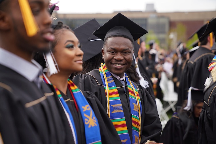 CU Denver students in cap and gown at commencement ceremony