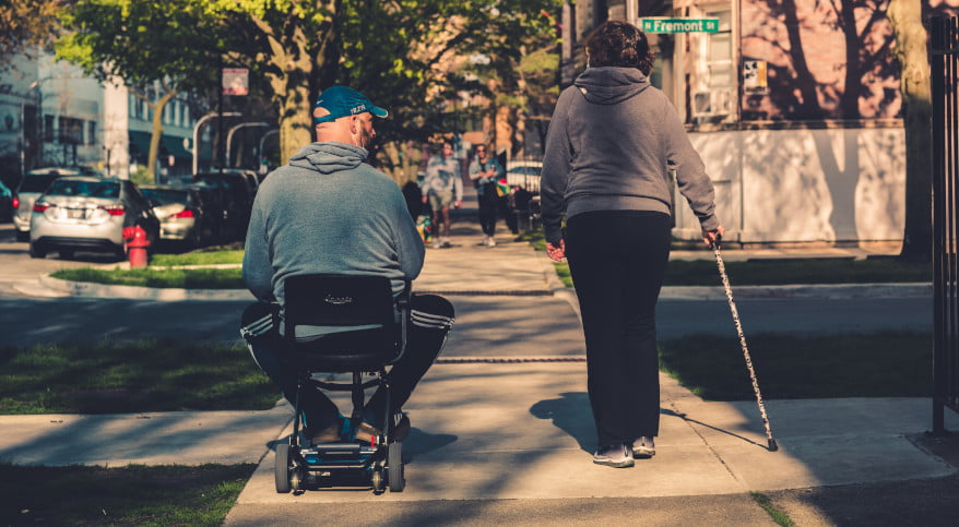person using a wheelchair and a cane