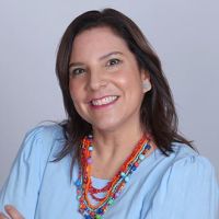 Headshot of Patricia Valverde smiling in business casual blouse and colorful beaded necklace