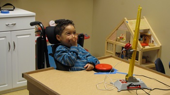a young boy interacts with a switch adapted toy