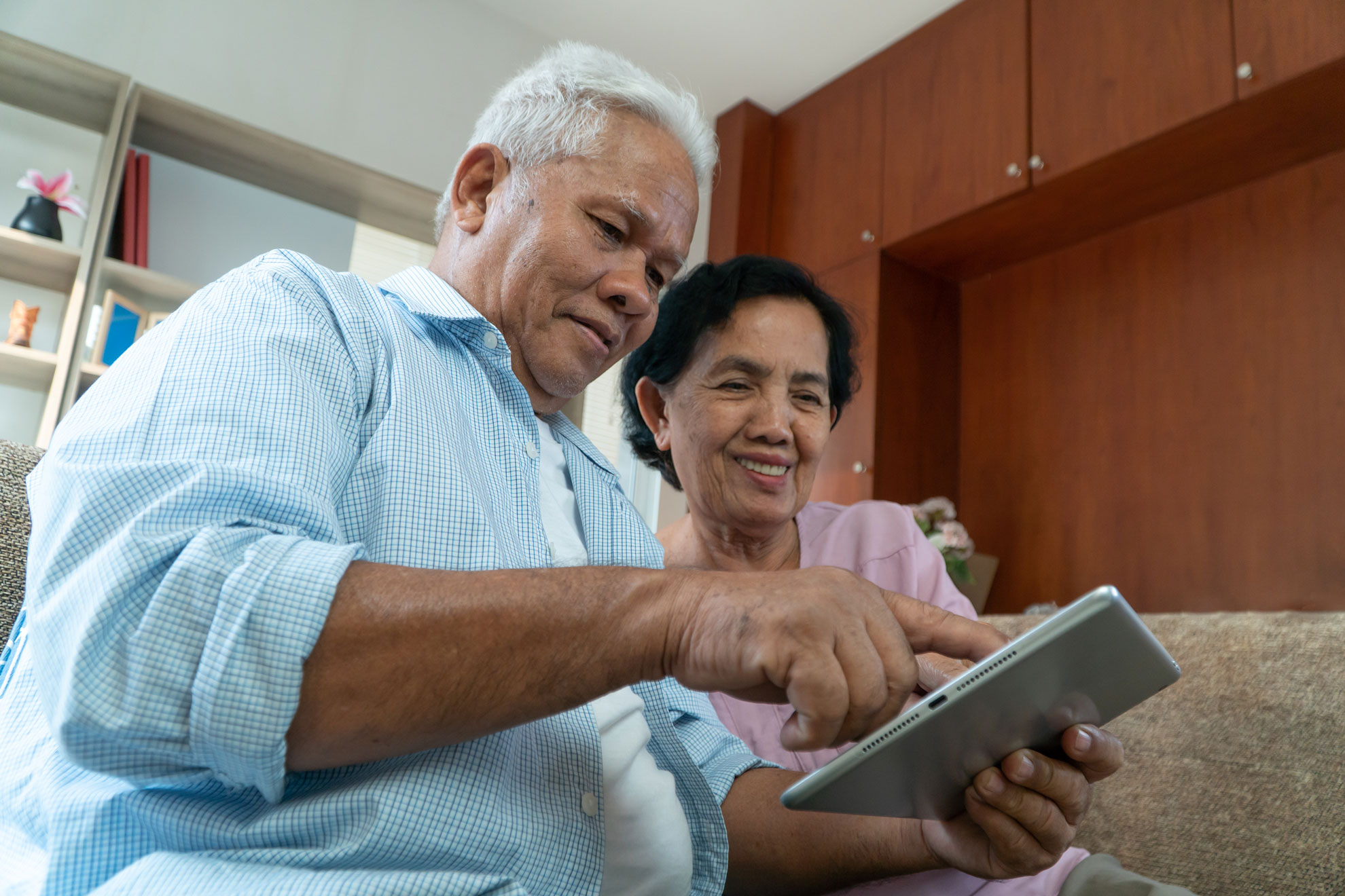 Older adult couple uses a tablet