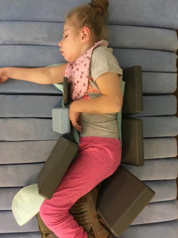 A child is supported lying on her side on a dreama mattress